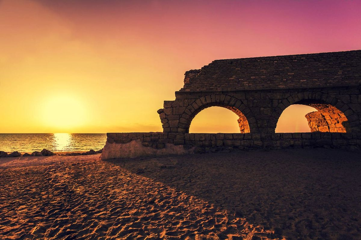 The Roman aqueduct at Caesarea on the Mediterranean shore at sunset