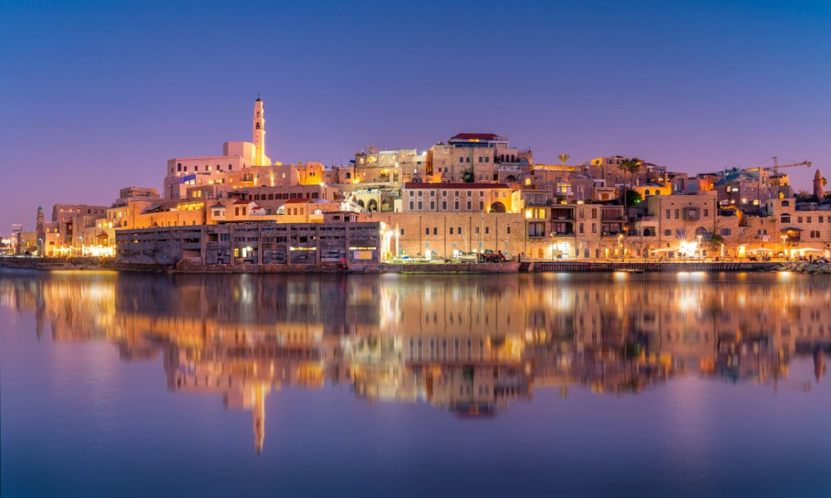 The old port of Jaffa lit up at dusk and reflected in the water